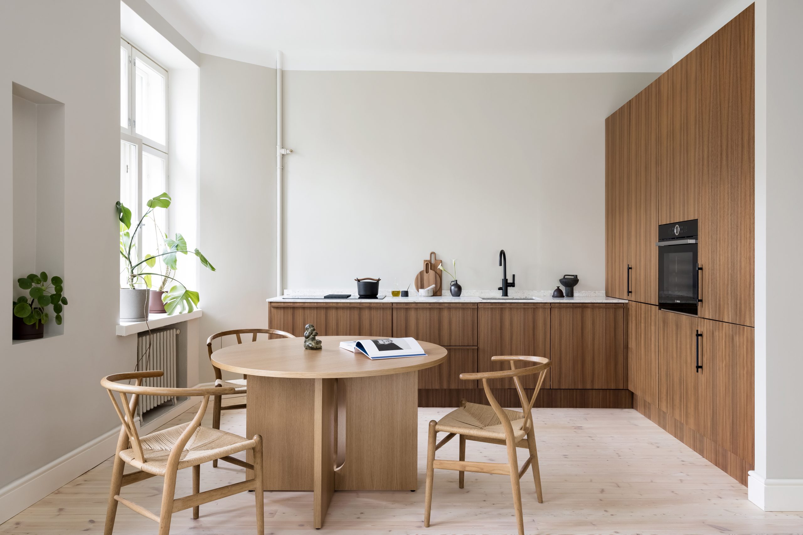 Blau keittiö Helsingissä, jossa pöhkinäpuu ovet ja marmoriterrazzo taso.