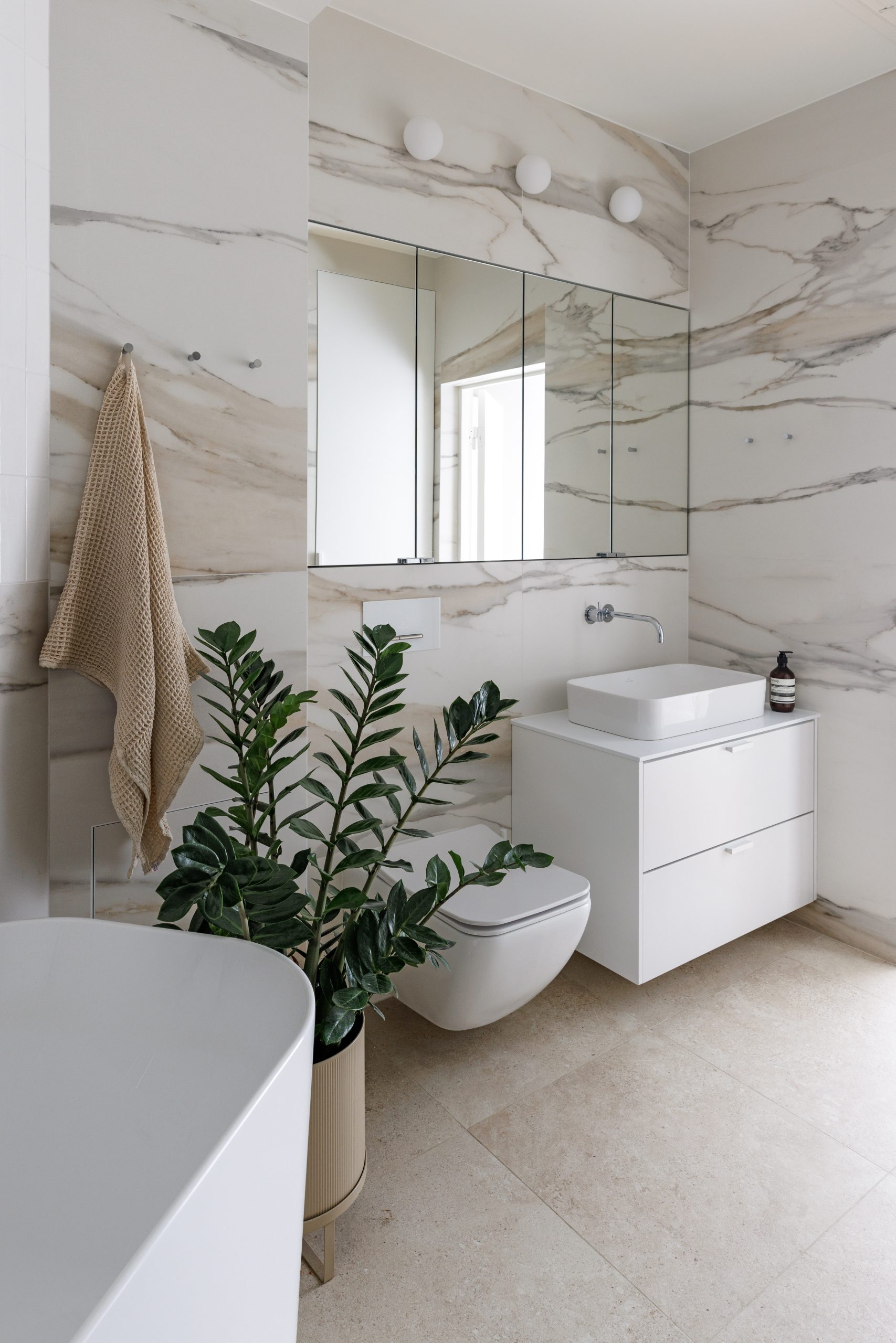 Blau kylpyhuone Helsingissä marmorilaattalla ja integroitu peilikaappi