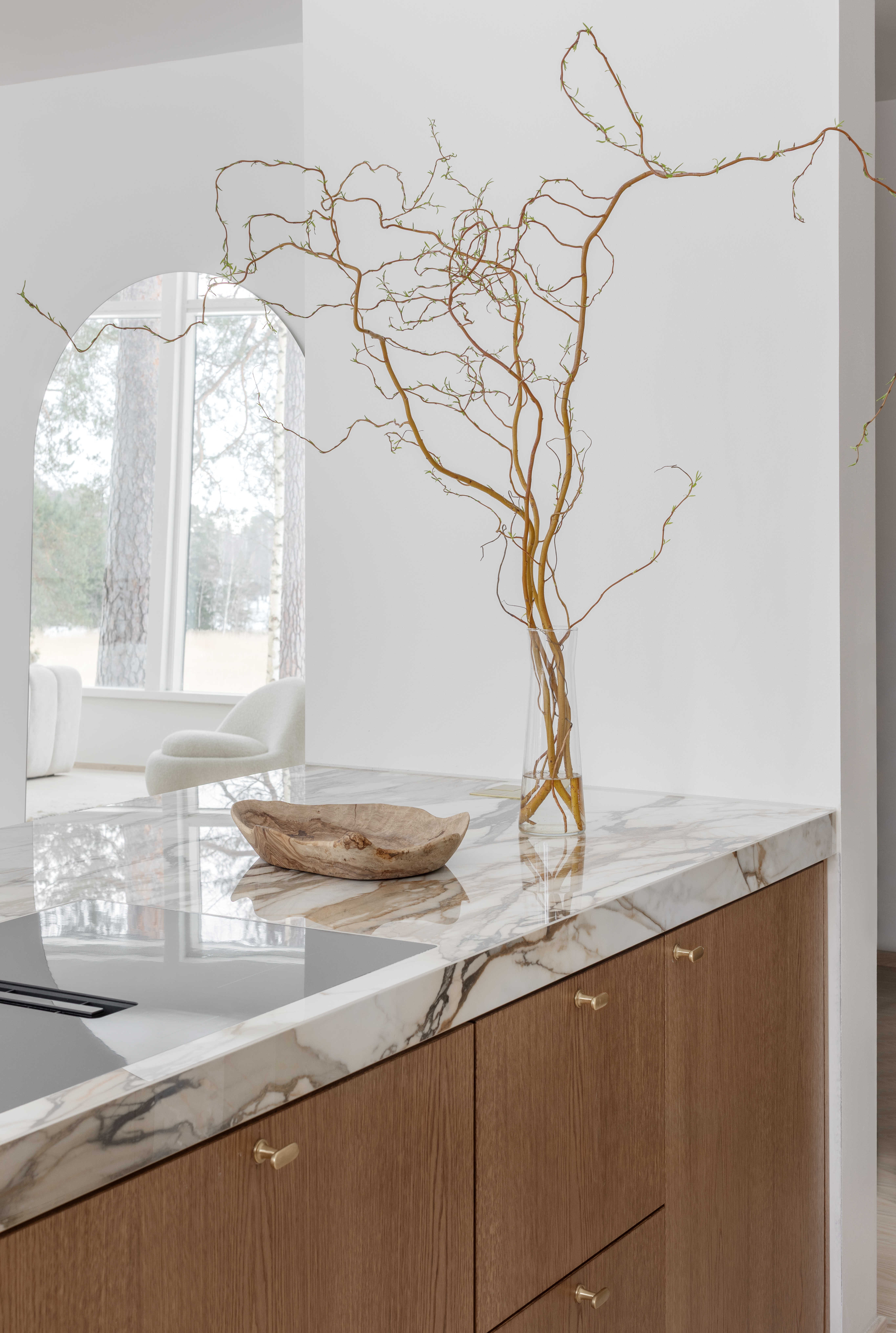 Moderni designkeittiö, jossa hiekan sävyinen mulperi-maalattu kaapisto, marmorikuvioinen keraaminen työtaso ja välitila sekä tummasta tammiviilusta tehty keittiösaareke.